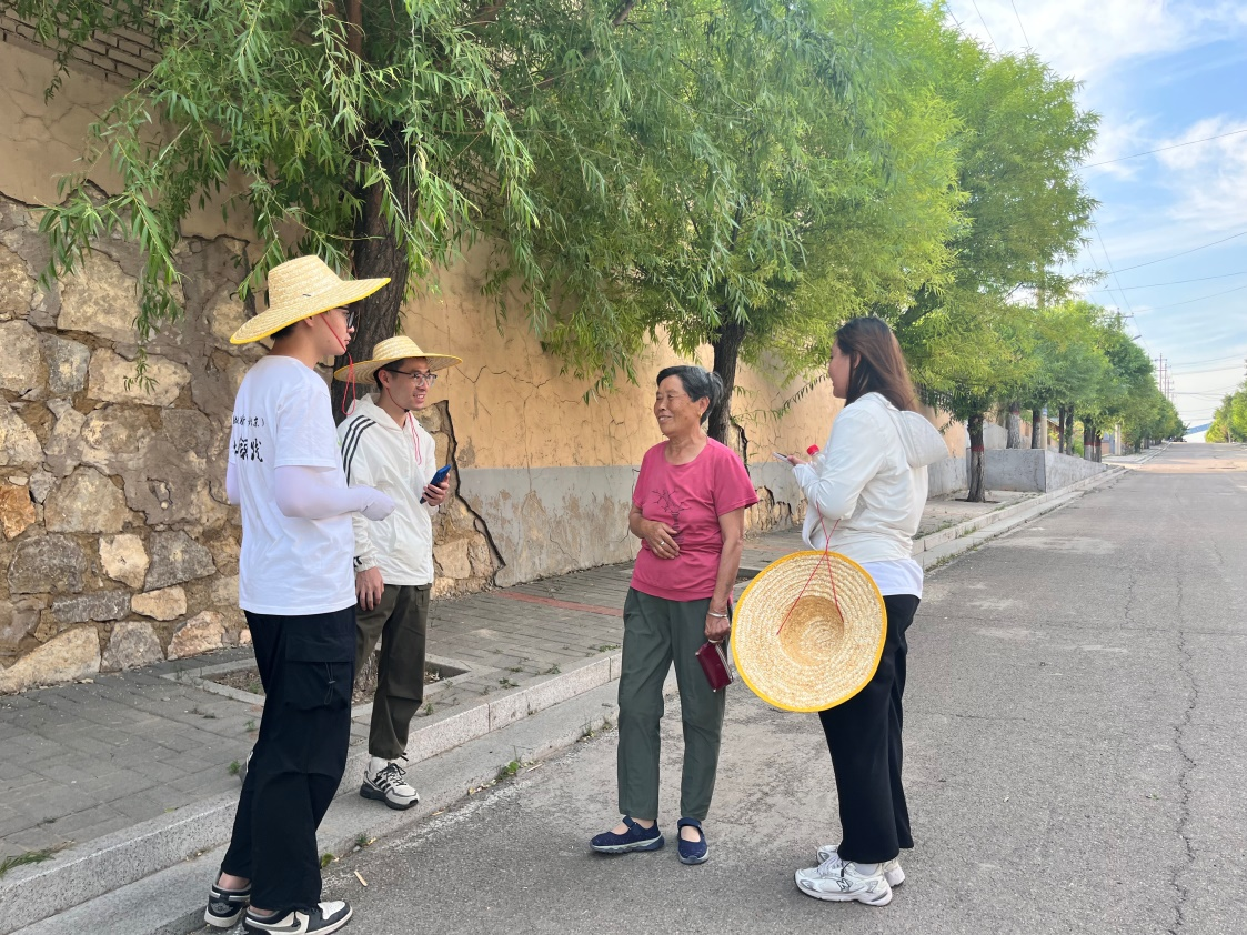 國(guó)土整治與生態(tài)修復(fù)實(shí)踐調(diào)研團(tuán)師生與村民交流。校方供圖